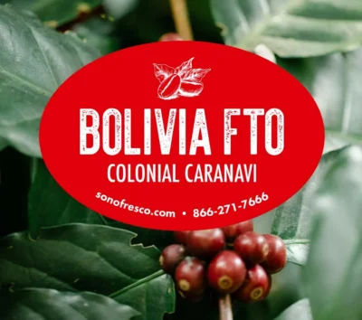 Bolivia FTO Colonial Caranavi label over close-up of ripe coffee cherries and green leaves