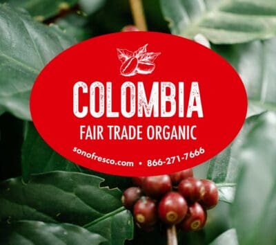 Colombia FTO green coffee label over ripe red coffee cherries and green leaves