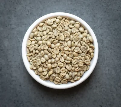 Bowl of Costa Rica Tarrazú SHB washed green coffee beans on a dark countertop