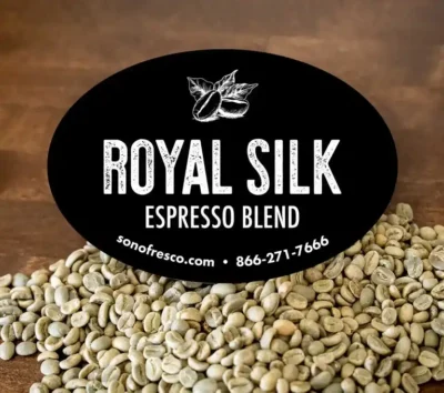 Royal Silk Espresso Blend label displayed in front of bags of green coffee beans.