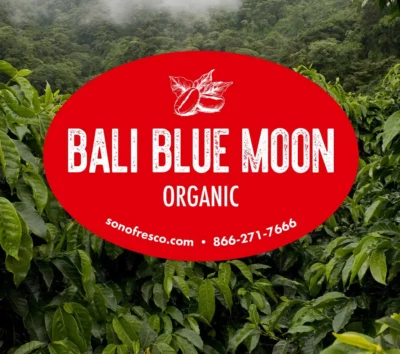 Bali Blue Moon Organic green coffee label over lush Indonesian coffee plants