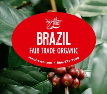 Brazil Fair Trade Organic coffee label over ripe red coffee cherries and green leaves
